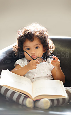 Buy stock photo Toddler, glasses or book read fun education, learning or childhood development knowledge. Little girl, sofa or story telling dress up professional or school work for funny, comedy or academic joke
