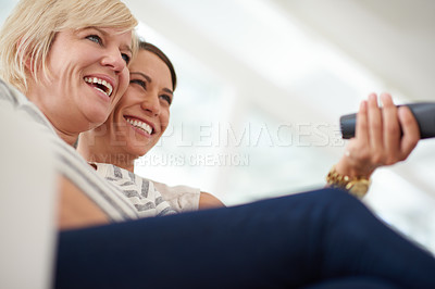 Buy stock photo Women, lesbian couple and tv remote for relax, entertainment and affection in home for bonding together. Female people, partner and tech in embrace, close or relationship on weekend for lgbt marriage