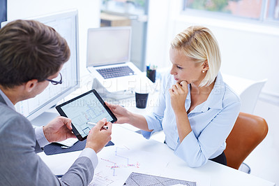 Buy stock photo Shot of a architect showing plans to his colleague on a digital tablet