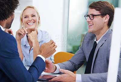 Buy stock photo Shot of three colleagues in an office laughing in a meeting

