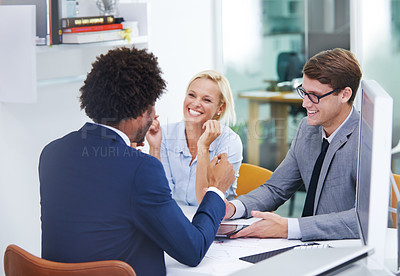 Buy stock photo Shot of three happy colleagues having a discussion in an office meeting