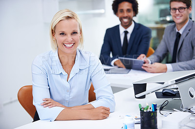 Buy stock photo Portrait of a confident businesswoman sitting with her colleagues in the background