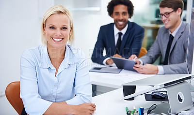 Buy stock photo Portrait of a confident businesswoman sitting with her colleagues in the background