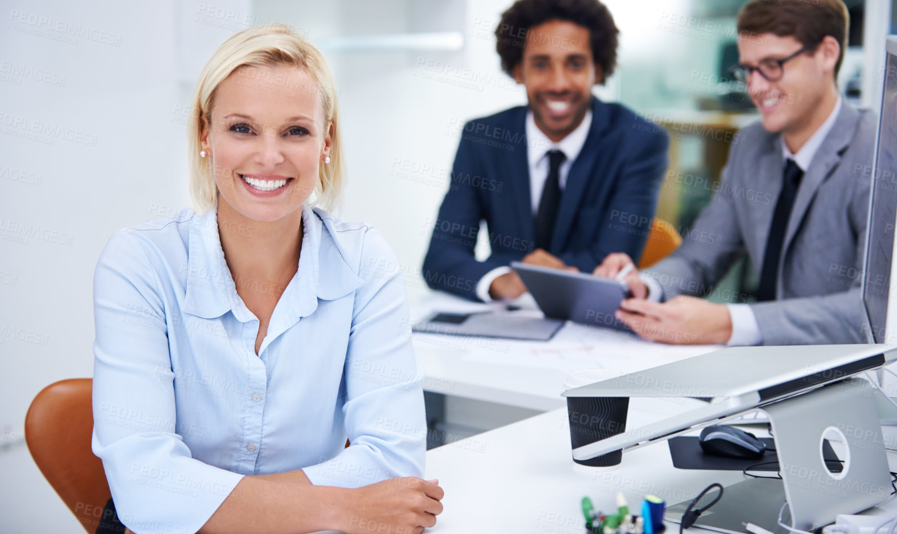 Buy stock photo Portrait of a confident businesswoman sitting with her colleagues in the background