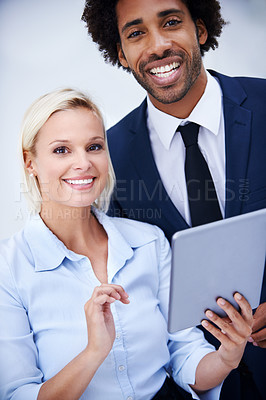 Buy stock photo Portait shot of two colleagues smiling happily together while holding a digital tablet