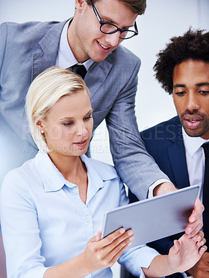 Buy stock photo Shot of a businessman showing colleagues something on a digital tablet