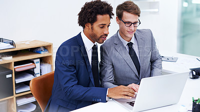 Buy stock photo Shot of two businessmen working together on a laptop
