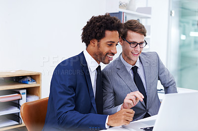 Buy stock photo Shot of male colleagues working together on a laptop