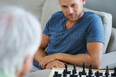 Buy stock photo Shot of a father and son playing a game of chess together at home