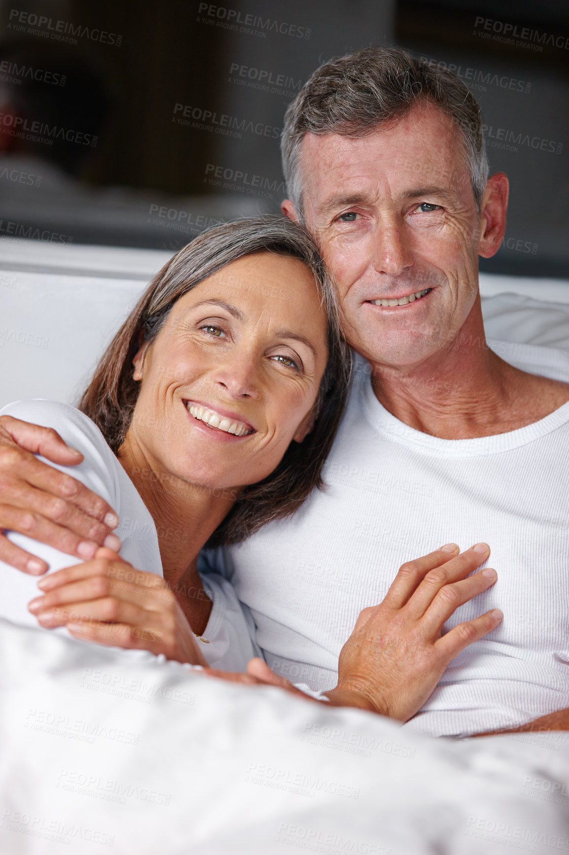 Buy stock photo Portrait of a loving mature couple cuddling in bed