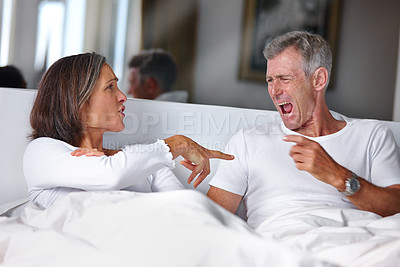 Buy stock photo Shot of a mature married couple having a heated argument in the bedroom