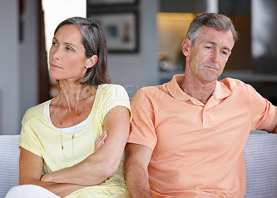 Buy stock photo Shot of a mature couple ignoring each other after having an argument