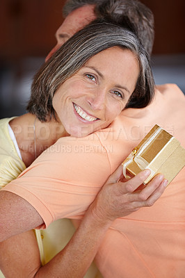 Buy stock photo Portrait of an attractive mature woman hugging her husband after receiving a gift from him