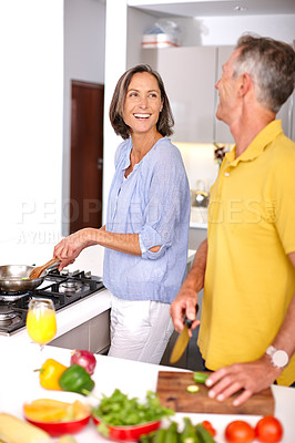 Buy stock photo Shot of a mature couple preparing a meal together in the kitchen
