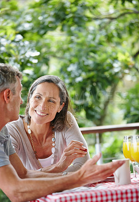 Buy stock photo Shot of a mature couple bonding while having breakfast together outdoors