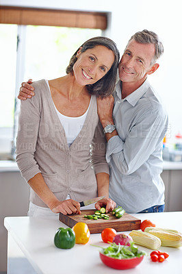 Buy stock photo Shot of a mature couple preparing a meal together in the kitchen