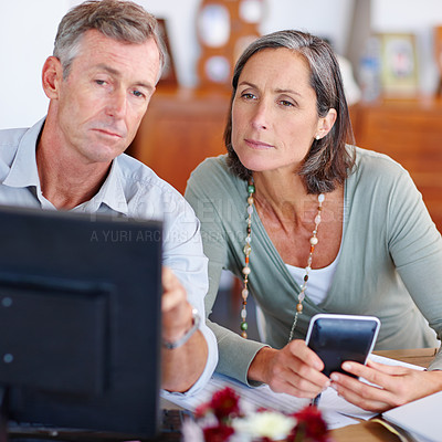 Buy stock photo Shot of a mature married couple going through their finances at home