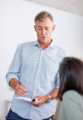 Buy stock photo Shot of a mature man discussing a document with his wife