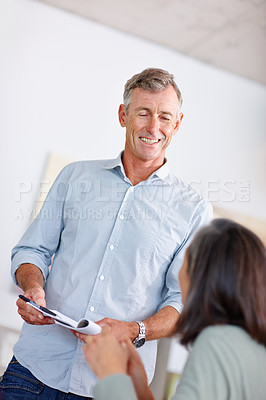 Buy stock photo Shot of a mature man discussing a document with his wife