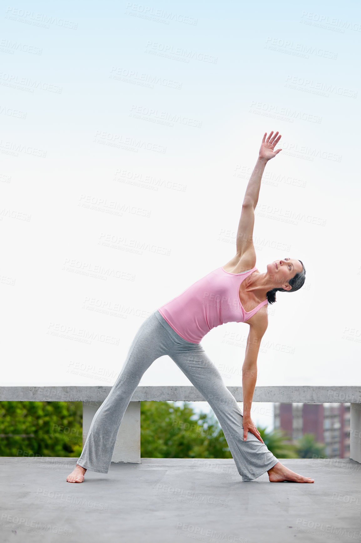 Buy stock photo Shot of an attractive mature woman doing yoga outdoors