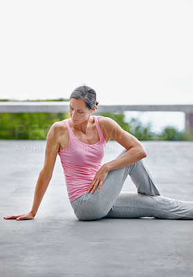 Buy stock photo Shot of an attractive mature woman doing yoga outdoors