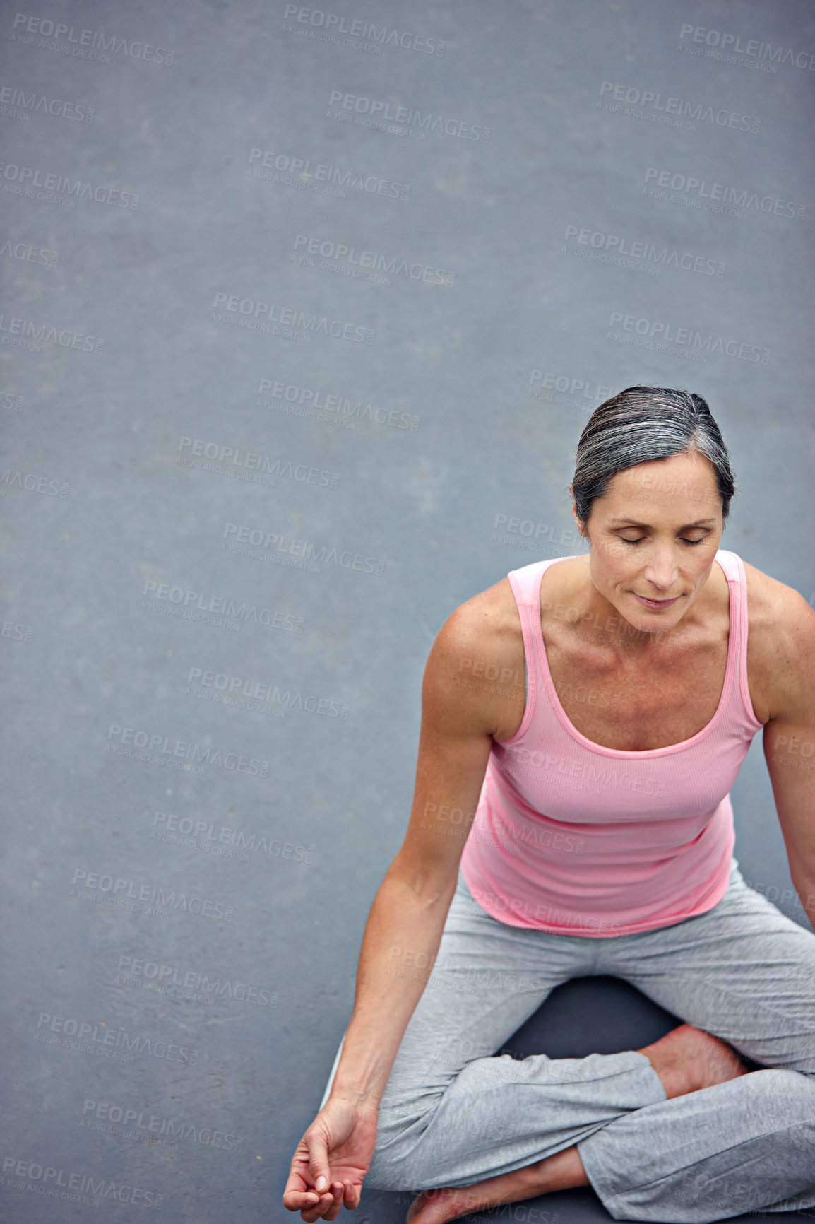 Buy stock photo Shot of an attractive mature woman practicing yoga in the lotus position