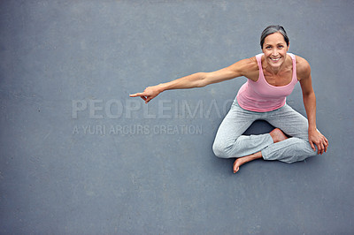 Buy stock photo High angle portrait of an attractive mature woman in gymwear pointing at copyspace