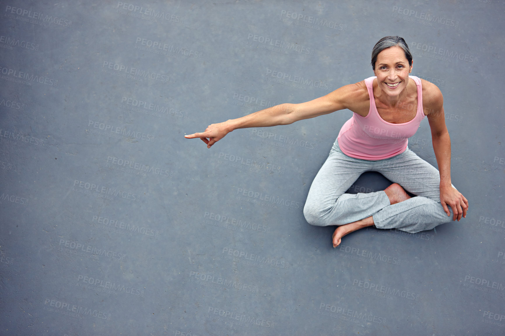 Buy stock photo High angle portrait of an attractive mature woman in gymwear pointing at copyspace