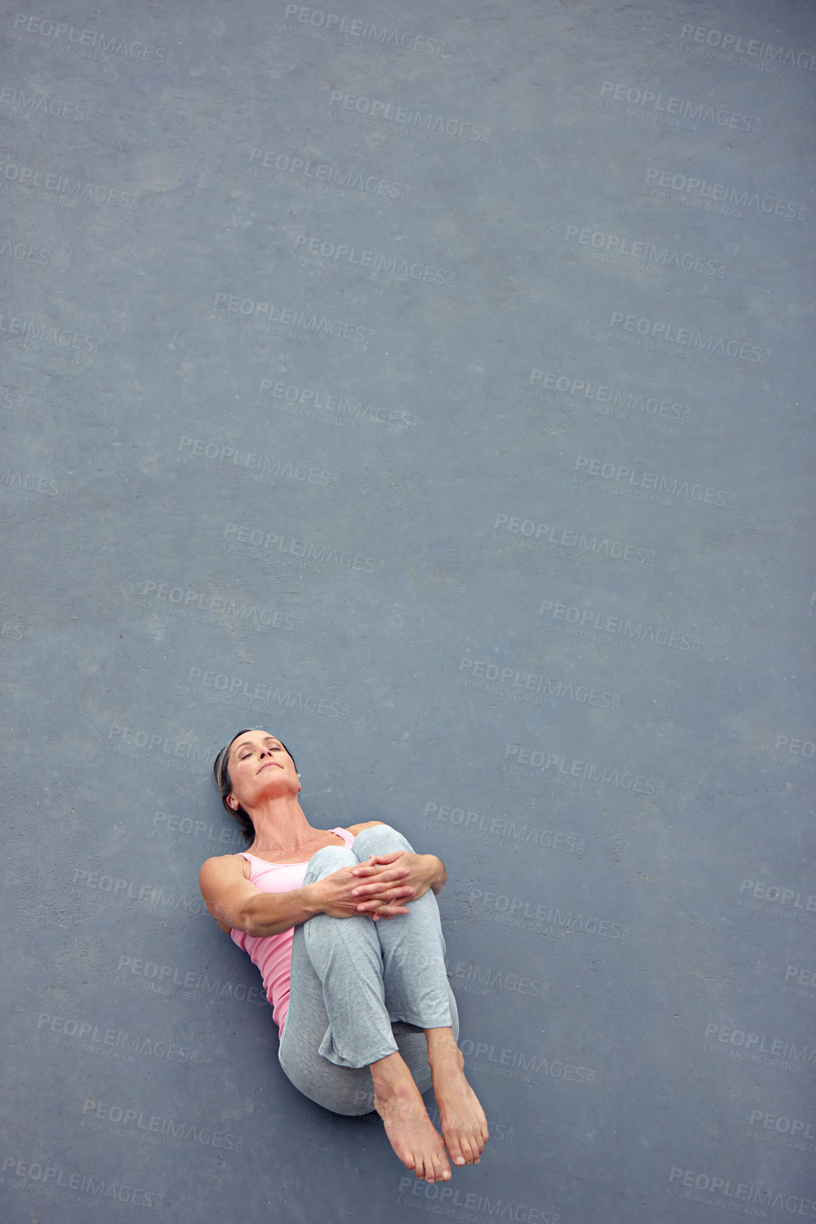 Buy stock photo High angle view of an attractive mature woman doing yoga outdoors