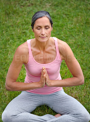 Buy stock photo Shot of an attractive mature woman practicing yoga in the lotus position