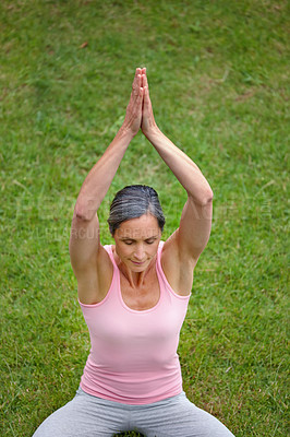 Buy stock photo Shot of an attractive mature woman doing yoga outdoors