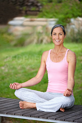 Buy stock photo Shot of an attractive mature woman practicing yoga in the lotus position