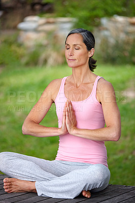 Buy stock photo Shot of an attractive mature woman practicing yoga in the lotus position