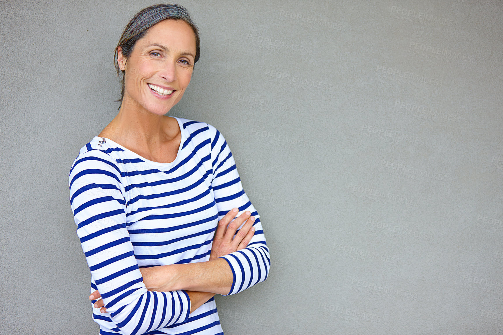 Buy stock photo Arms crossed, portrait and smile with mature woman on gray background in studio for trendy style. Clothes, fashion and stripes with happy person on empty mockup space to model outfit or wardrobe