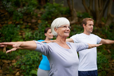 Buy stock photo Shot of a senior woman enjoying an outdoor yoga class