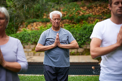 Buy stock photo Shot of a senior man meditating in an outdoor yoga class