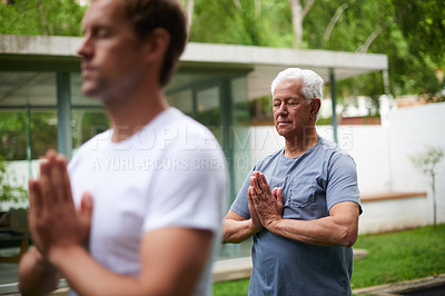 Buy stock photo Shot of a senior man meditating in an outdoor yoga class