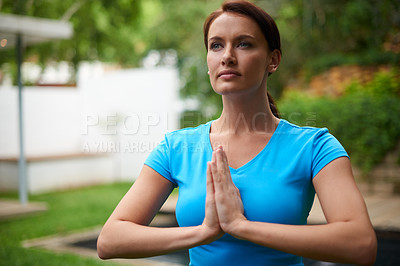 Buy stock photo Shot of a young woman in a meditative yoga pose outdoors
