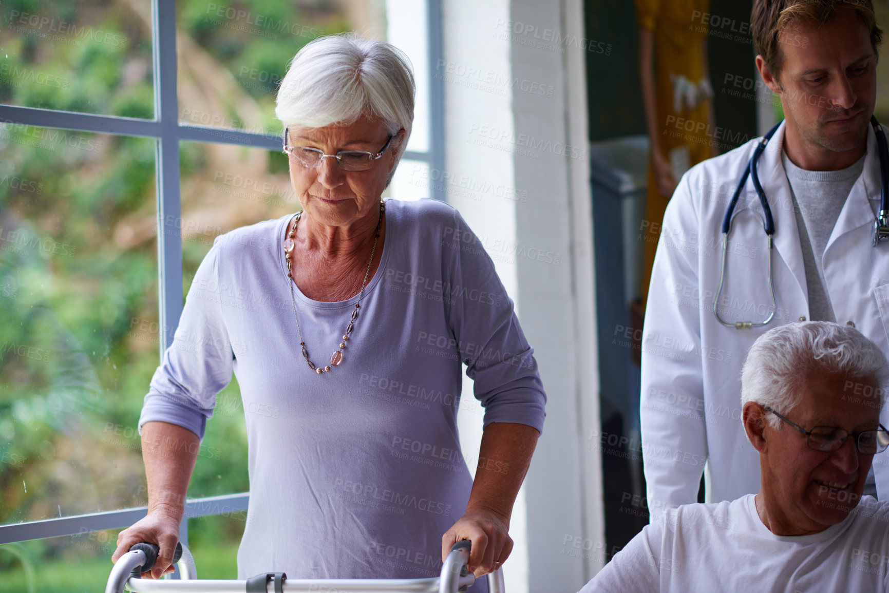 Buy stock photo Doctor, senior couple with disability and walking in hopsital for healthcare or medical treatment. Mobility walker, rehabilitation and retirement with old people in clinic for appointment or checkup