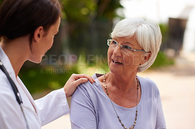Buy stock photo Shot of a senior woman talking to her doctor outdoors