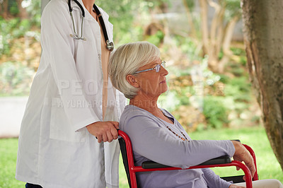 Buy stock photo Shot of a senior woman in a wheelchair being pushed by her doctor