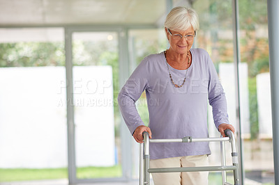 Buy stock photo Shot of a senior woman walking with care, using an orthopedic walker