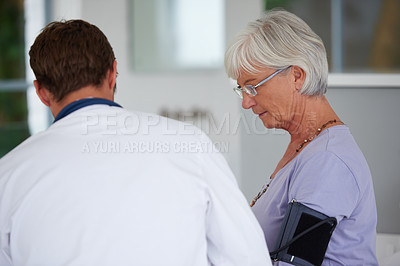 Buy stock photo Shot of a senior woman having her blood pressure checked by her doctor