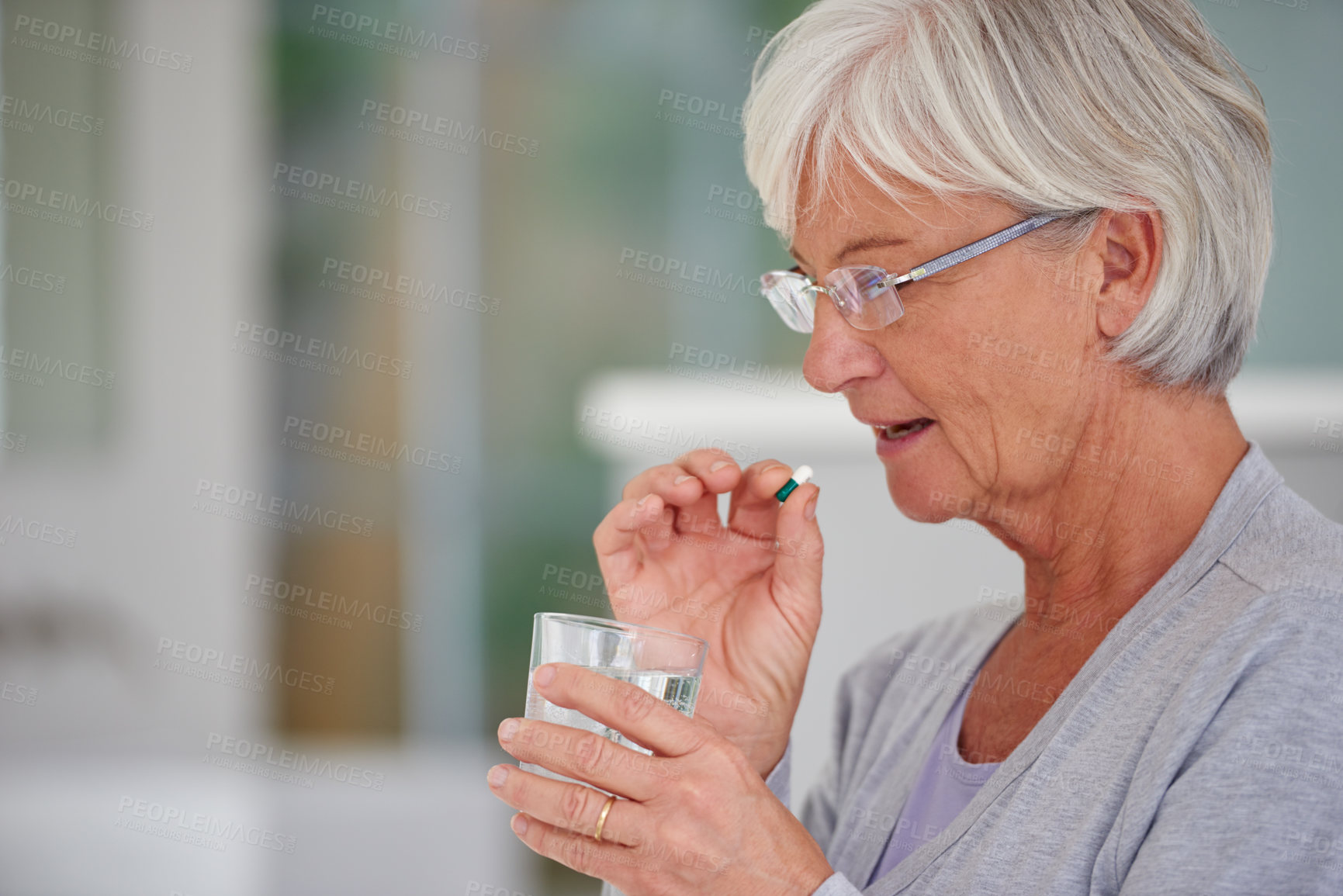 Buy stock photo Medication, health and woman drinking a pill for recovery, medical problem or wellness at a retirement home. Medicine, sick and senior female person taking a prescription tablet with a glass of water