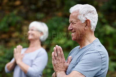 Buy stock photo Shot of a senior man doing yoga with his wife outdoors