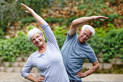 Buy stock photo Shot of a senior couple doing yoga together outdoors