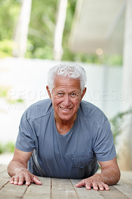 Buy stock photo Shot of a senior man doing yoga on an outdoor patio