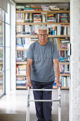 Buy stock photo Portrait of a senior man standing with the assistance of a walker indoors