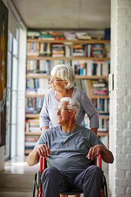 Buy stock photo Shot of a senior woman standing behind her husband who's in a wheelchair