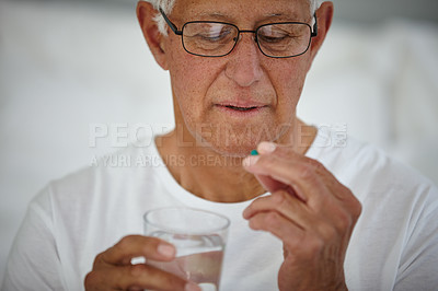 Buy stock photo Cropped shot of a senior man taking his medicine